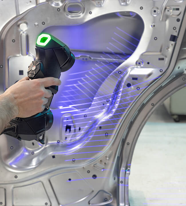 Technician using a Creaform HandySCAN 3D scanner to capture detailed 3D measurements of a car brake system, with projected laser grids visible on the components.